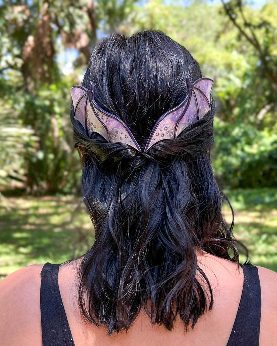 Hair combs for dragon lovers featuring two large combs in the shape of dragon wings with engraved details and a pearlescent purple color.