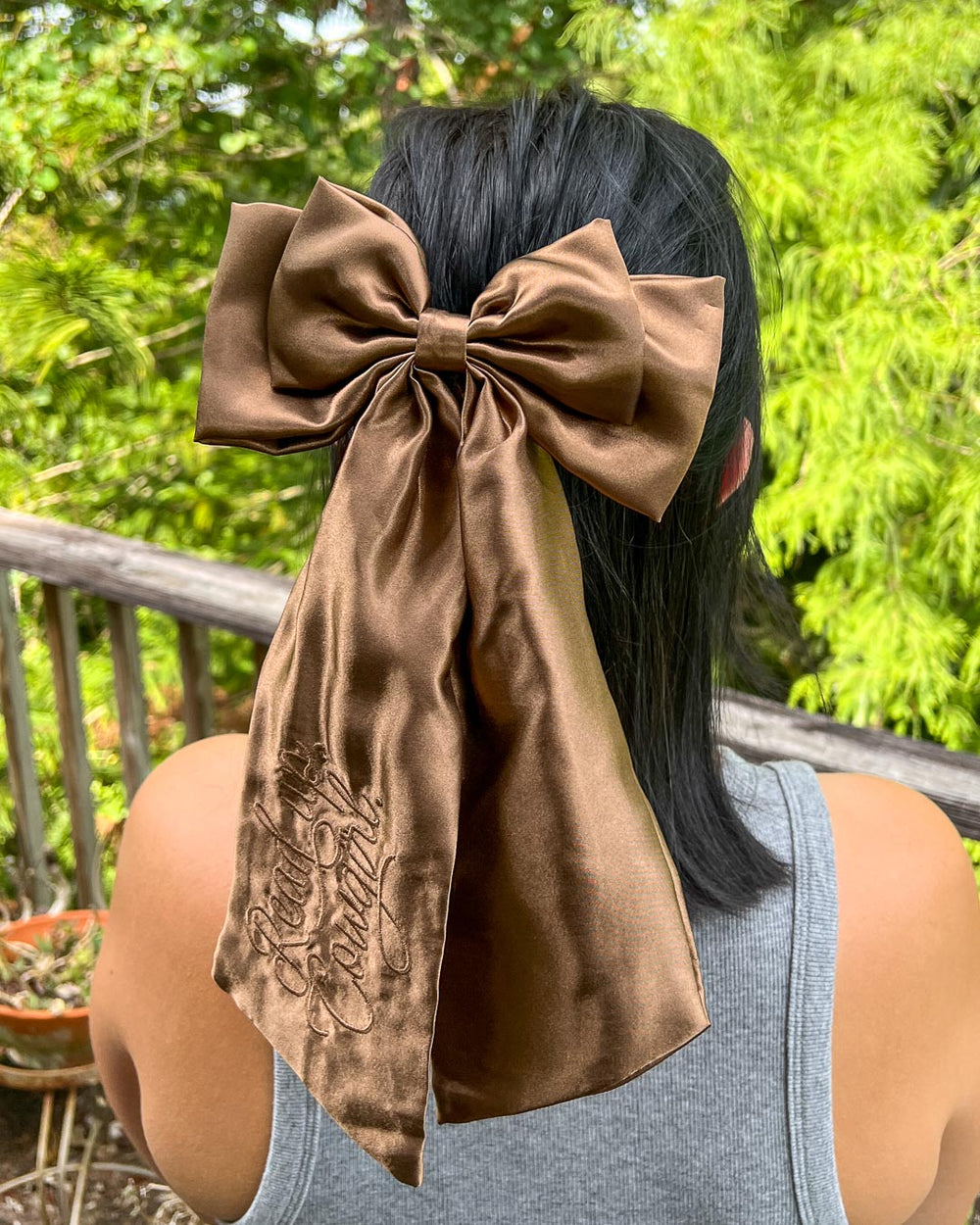 Bookish hair accessory for romance readers with shiny, brown satin and the phrase 'Read Up, Cowgirl' embroidered on the hair bow.