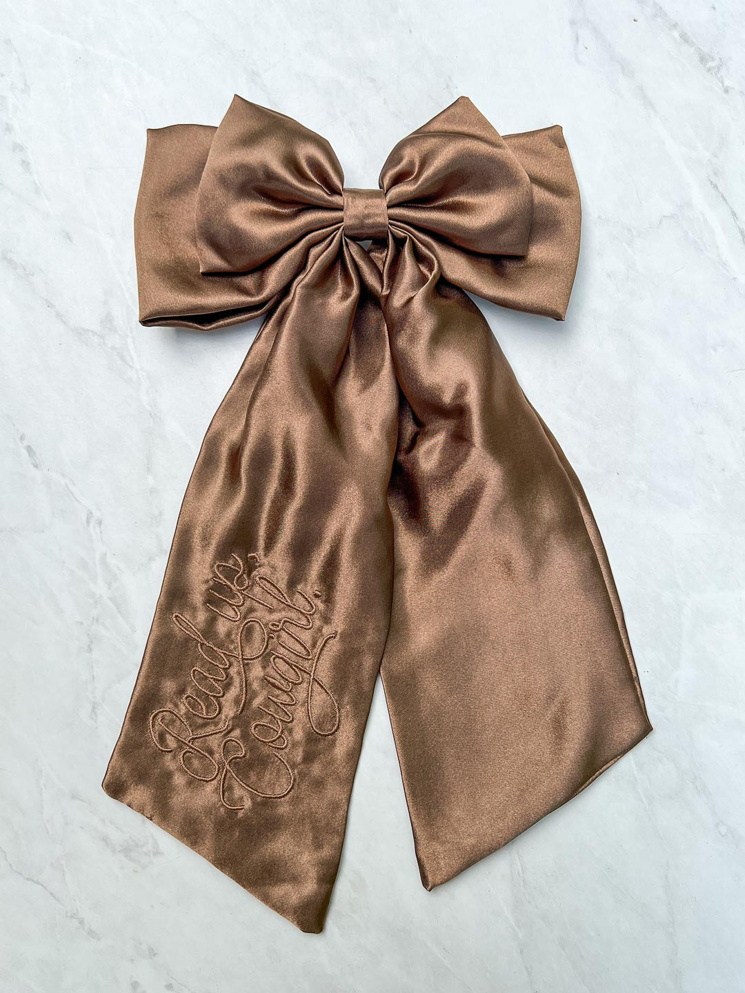 Embroidered hair bow designed in shiny brown satin with &