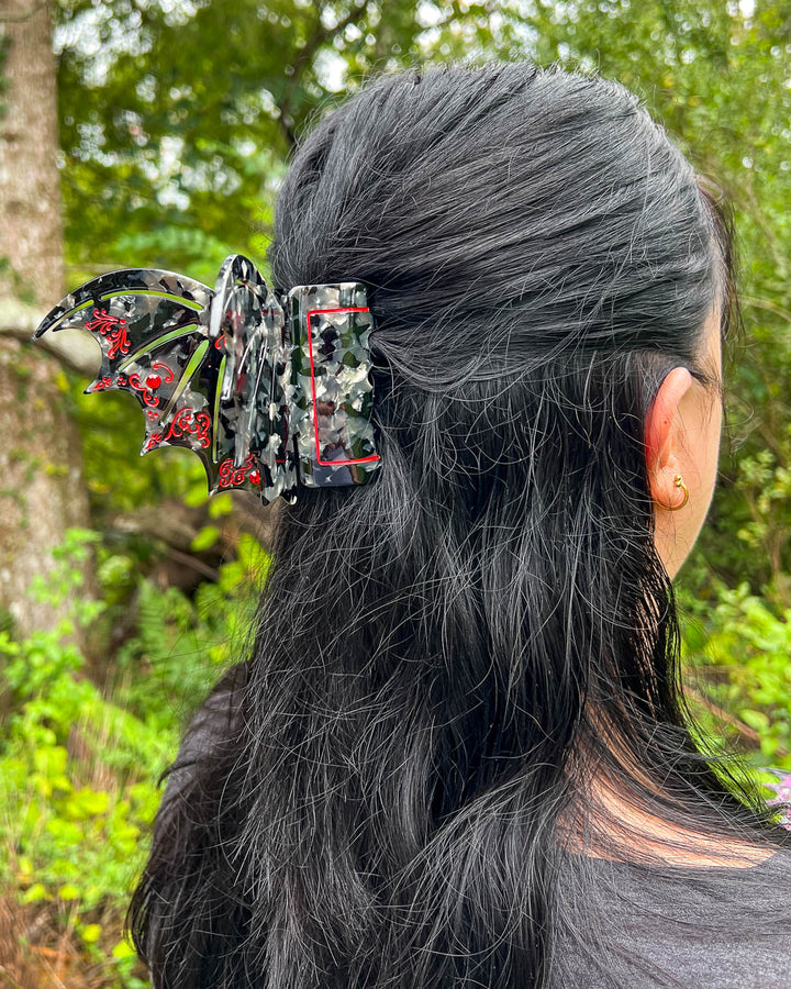 Bookish hair clip in red and back with red gem embellishments in the shape of bat wings inspired by ACOTAR.