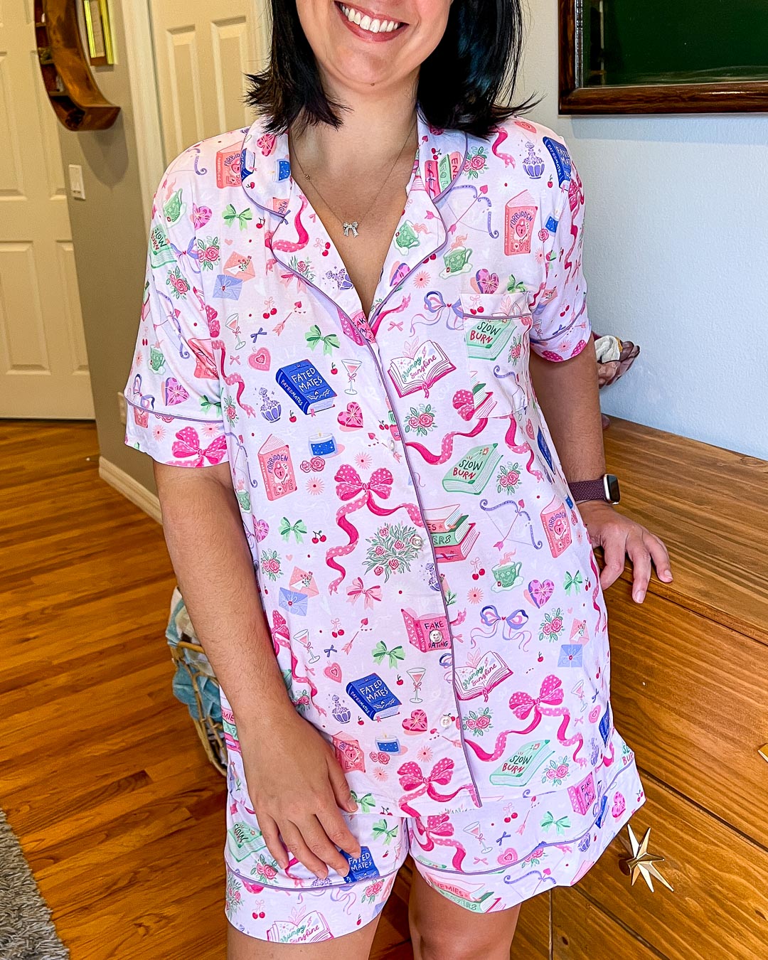 Romance pajamas for tropes with illustrated designs of books, bows, drinks, arrows, hearts, and more.