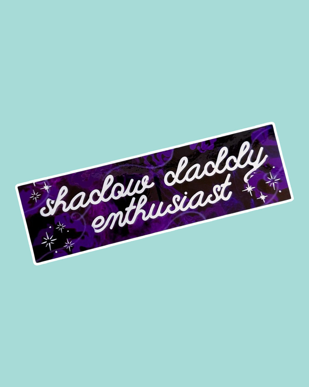 Swirling purple and black bookish bumper sticker about loving shadow daddies with doodling text and sparkles.