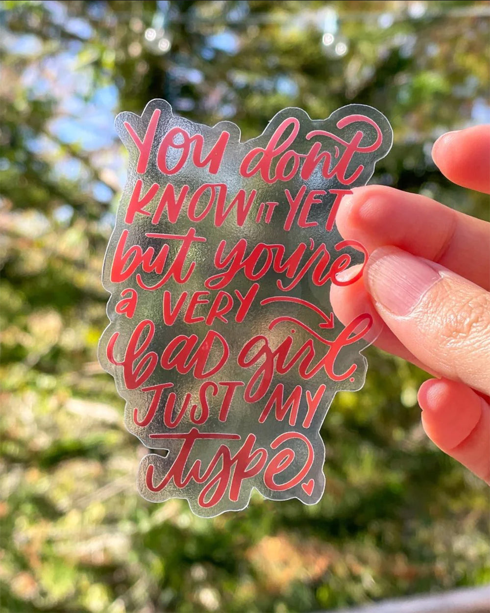 Shatter me merchandise featuring the quote 'You don't know it yet but you're a very bad girl. Just my type,' on a transparent sticker.