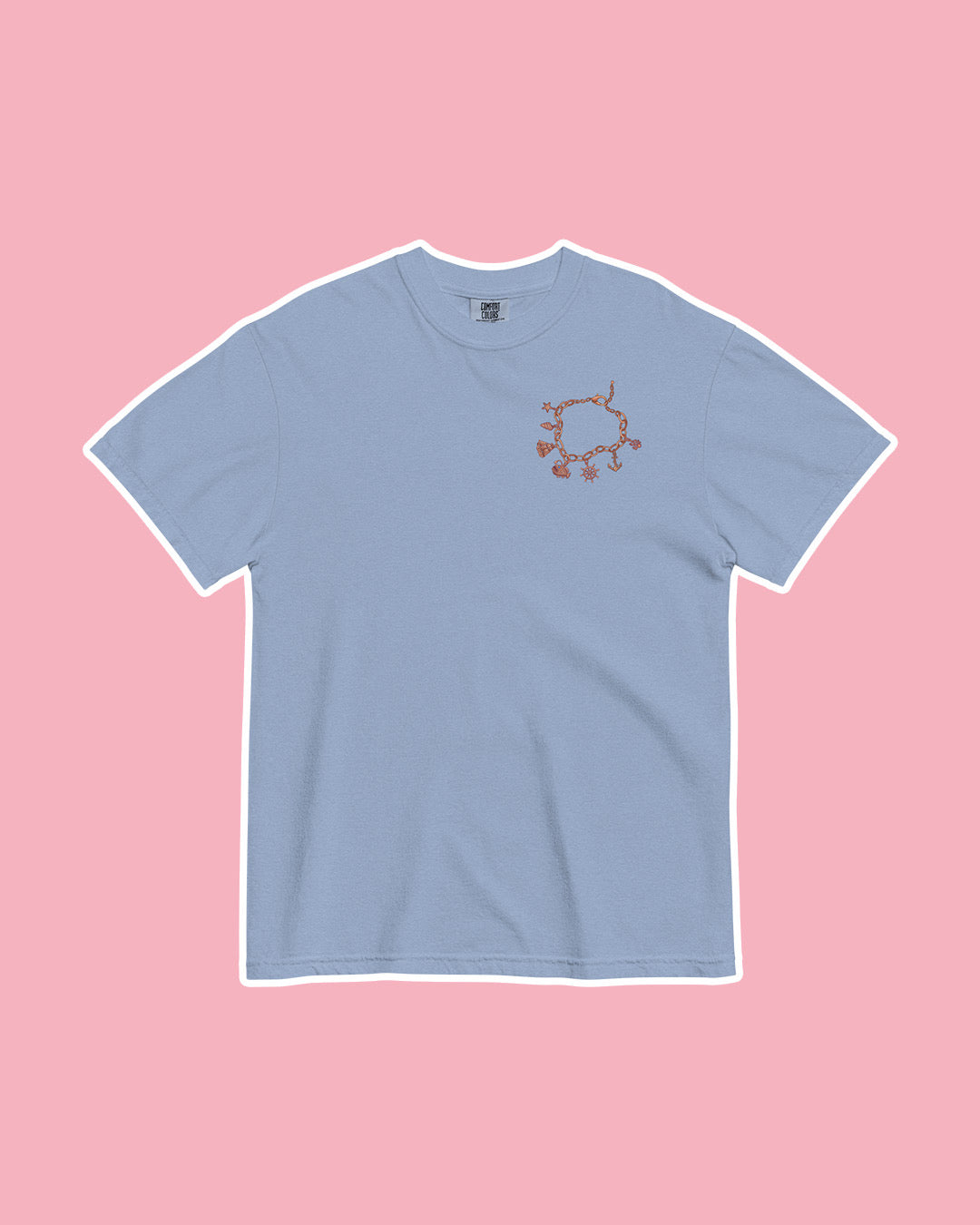 Blue t-shirt on pink background with an illustrated charm bracelet printed on the top left chest inspired by Half City by Kate Golden.