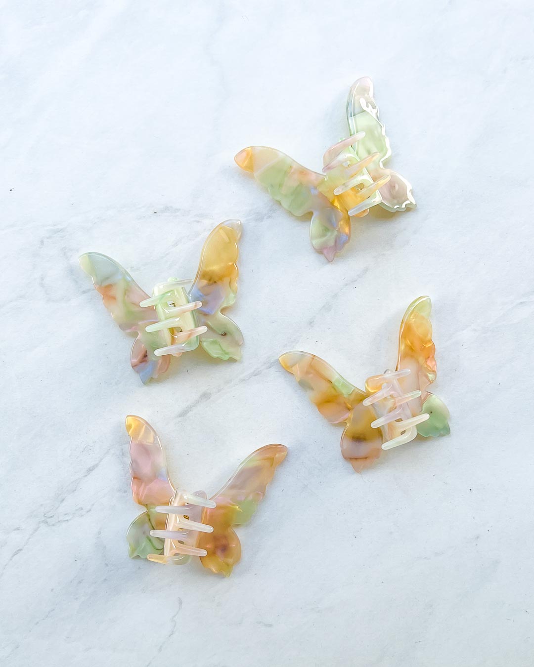 Mini hair clips for fantasy fans featuring gold iridescent clips in shape of fairy wings with gem embellishments and etching details.