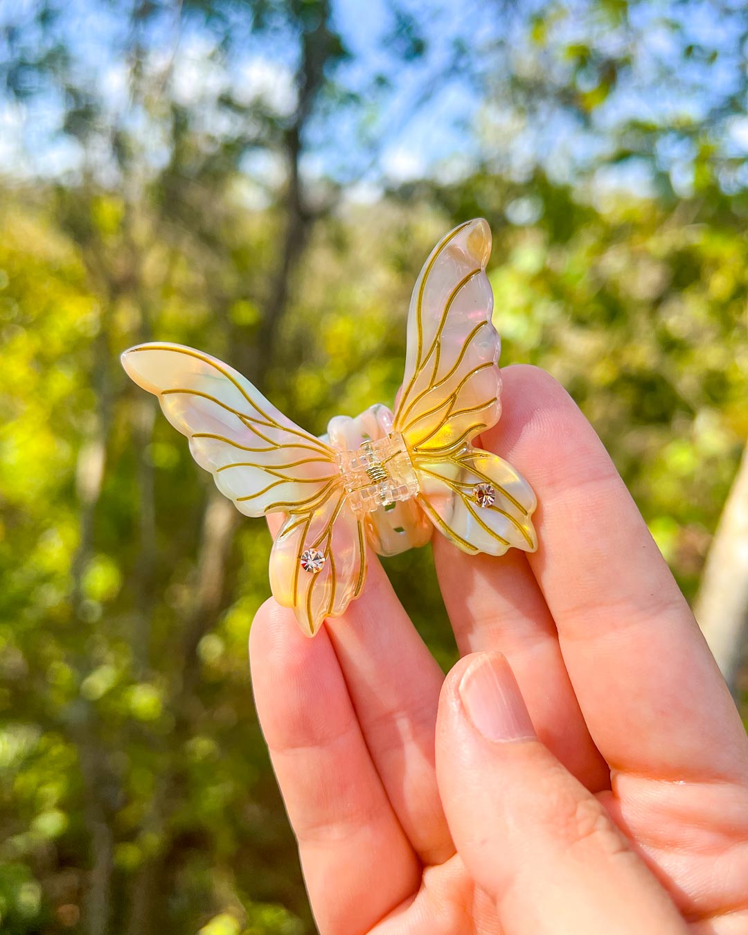 Fantasy mini hair clips in the shape of fairy wings in gold iridescent with etchings and gem embellishments.