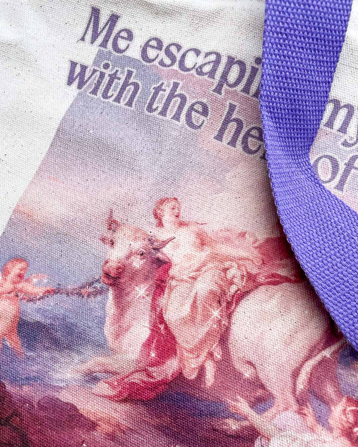 Close up of the fine art tote bag featuring sparkles, a colorful classic painting, and purple straps.