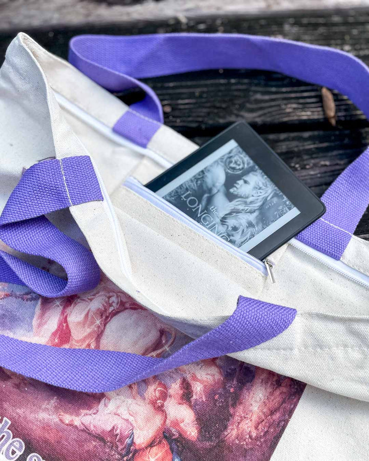 Close up of the smuttiest book tote bag highlighting the purple straps and the zippered inside pocket.