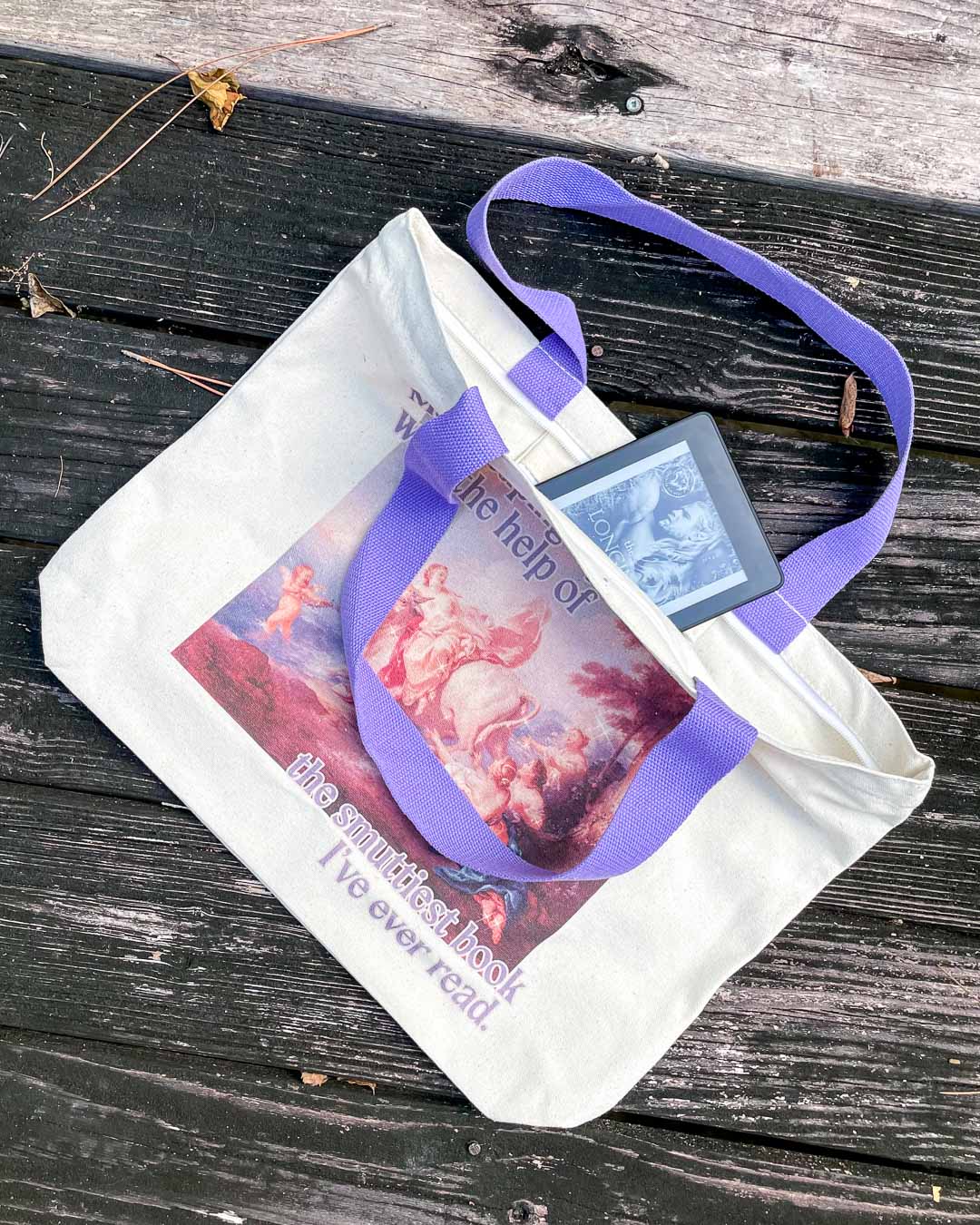 Bookish tote bag with purple straps, an inside pocket, and a zipper featuring a colorful fine art painting and the phrase, &