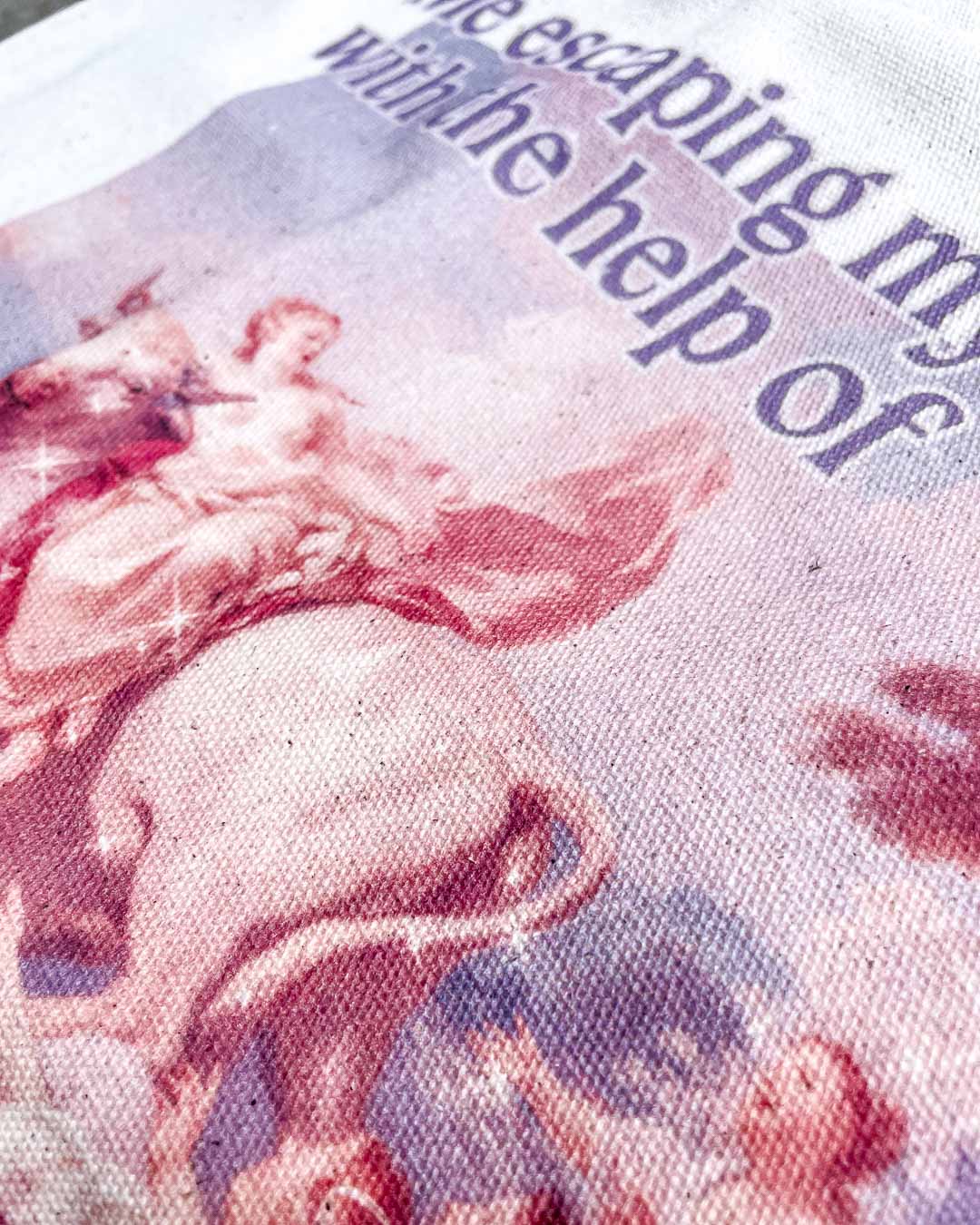 Close up of the romance tote bag highlighting the colorful fine art painting and the quote, &