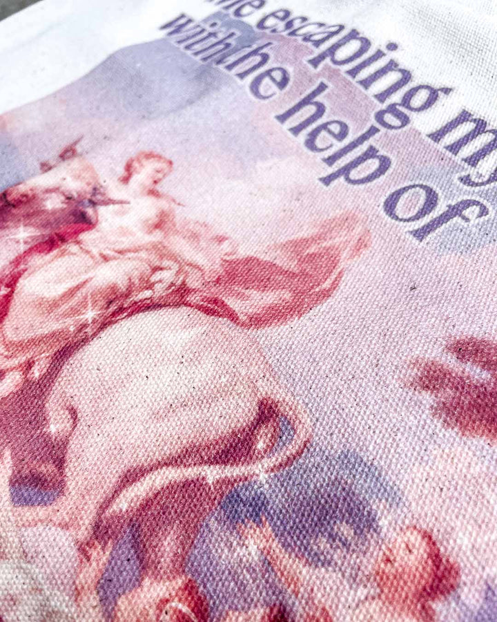 Close up of the romance tote bag highlighting the colorful fine art painting and the quote, &