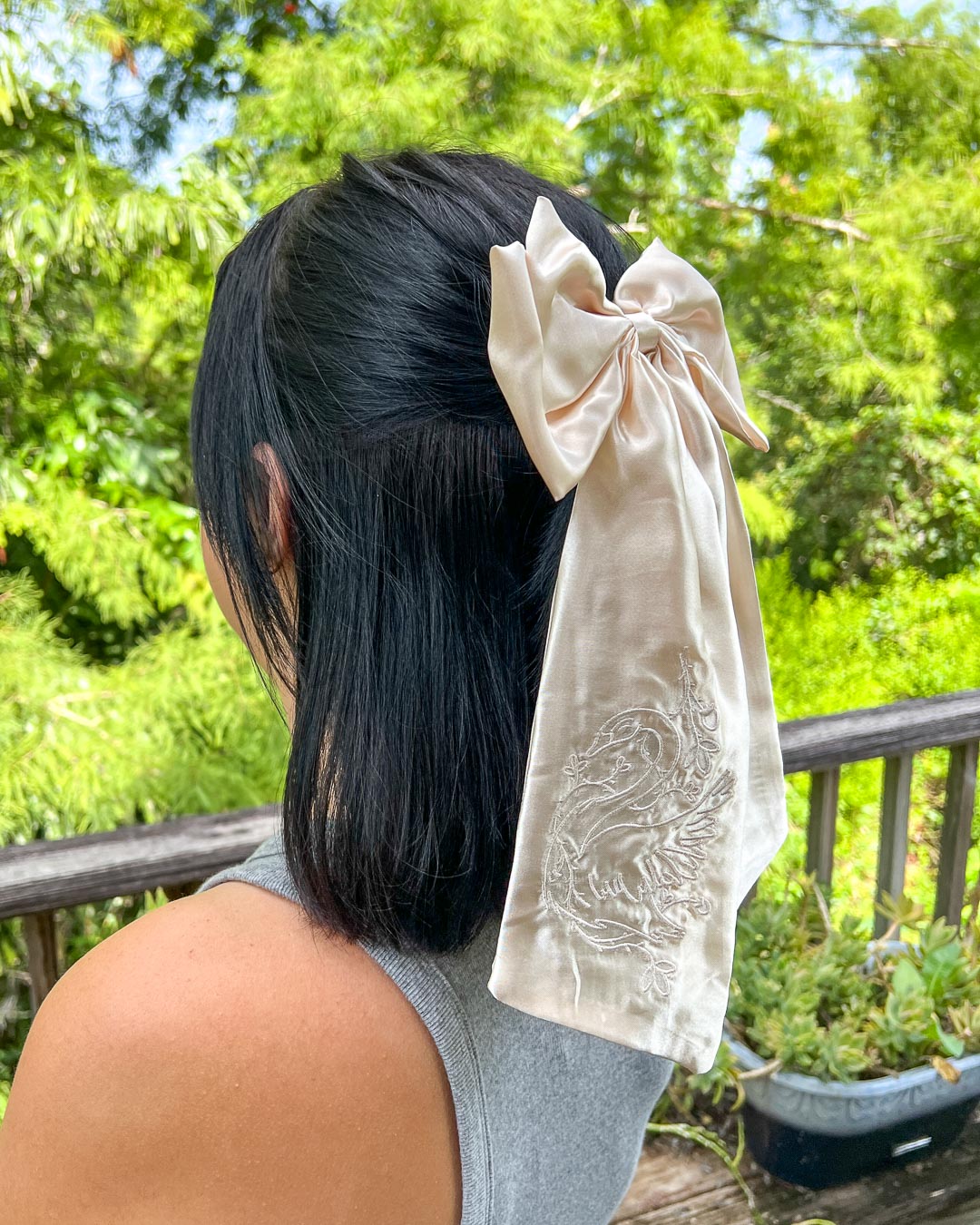 Embroidered hair bow designed in ivory satin with a swan wrapped in ivory embroidered on the hair accessory.