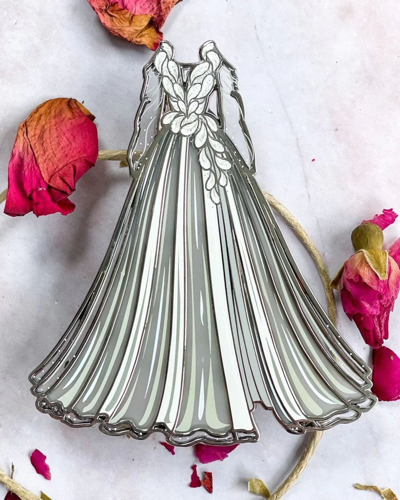 Serpent & Dove pin for Shelby Mahurin fans featuring Lou's white gown costume for Troupe de Fortune embellished with transparent details.