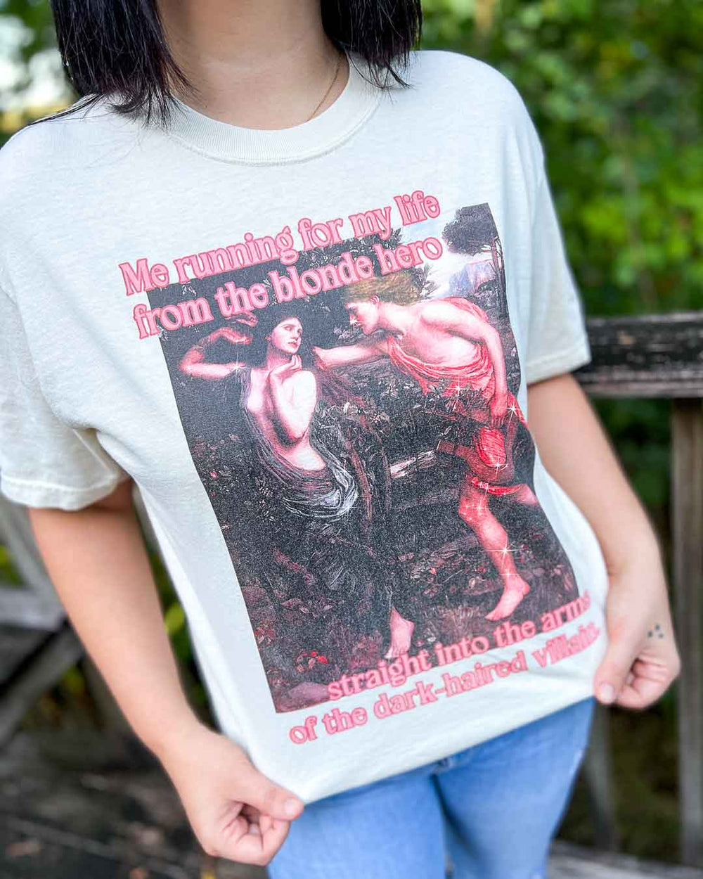 Bookish tee for romance fans featuring a fine art painting with the quote, 'Me running for my life from the blonde hero straight into the arms of the dark-haired villain.'