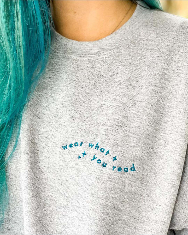 Close up of the Blissfully Bookish sweatshirt with &