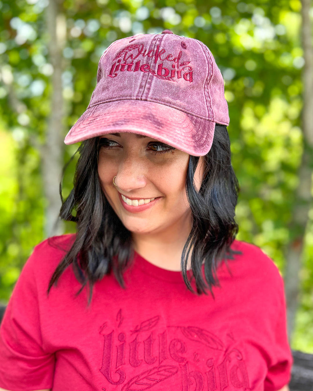 A maroon Sacred Stones hat for A Dawn of Onyx fans featuring the nickname 'Wicked Little Bird' embroidered on the front.