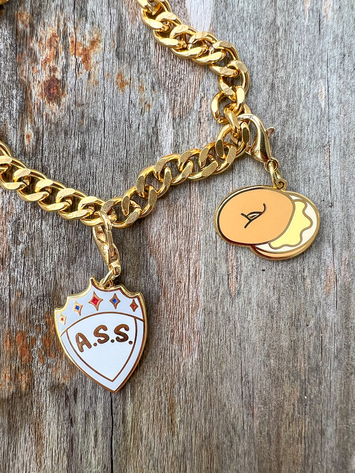 Zodiac Academy charms featuring a bagel and an A.S.S. shield.