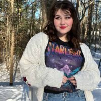 person standing outside wearing theCity of Starlight Vintage Location Tee from A Court of Thorns and Roses Outside in the Winter with a cardigan and jeans