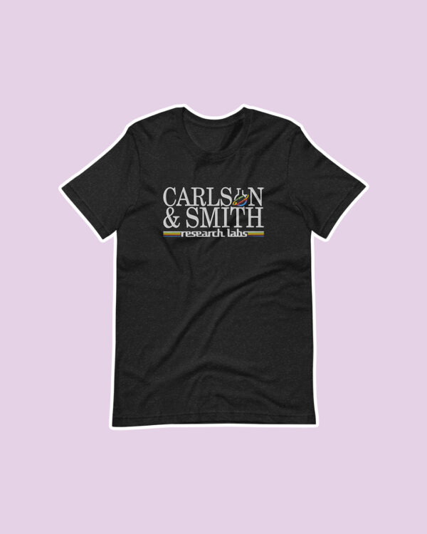 black shirt with an embroidered design reading "carlson & smith research labs" on a purple background.