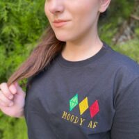 Girl wearing a black shirt with a design reading "moody AF"