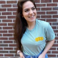 Girl wearing a robin's egg blue colored shirt with embroidered design reading "ctrl+shift+c motherlode".