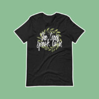black boyfriend tee shirt with laurel wreath and white text trees speak latin design shirt is on a green background