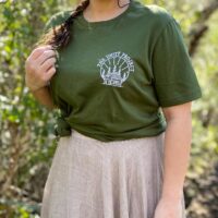 Person wearing a green shirt with an embroidered design reading "the unity project".