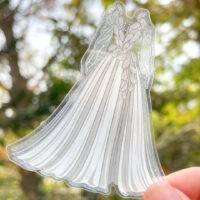 fingers holding transparent sticker of the novel threads design for the troupe de fortune costume